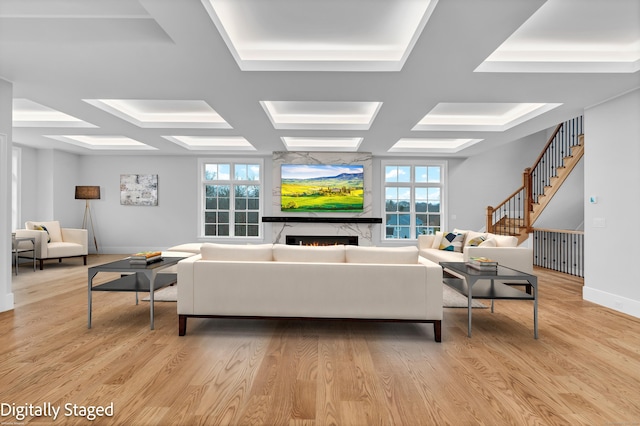 living room featuring light wood-type flooring, plenty of natural light, and coffered ceiling