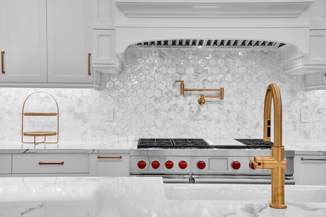 kitchen with decorative backsplash, custom range hood, white cabinets, and light stone counters