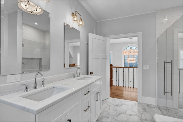 bathroom with a notable chandelier, a shower with shower door, and vanity