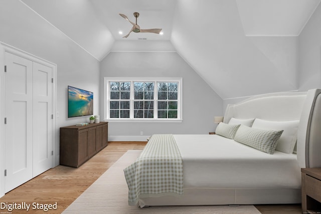 bedroom featuring light wood-type flooring, a closet, vaulted ceiling, and ceiling fan