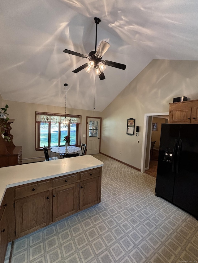 kitchen with ceiling fan, black fridge, lofted ceiling, and decorative light fixtures