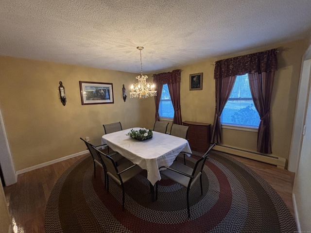 dining room featuring a textured ceiling, wood-type flooring, baseboard heating, and a chandelier