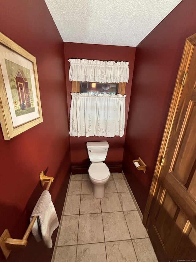 bathroom with tile patterned floors, toilet, and a textured ceiling