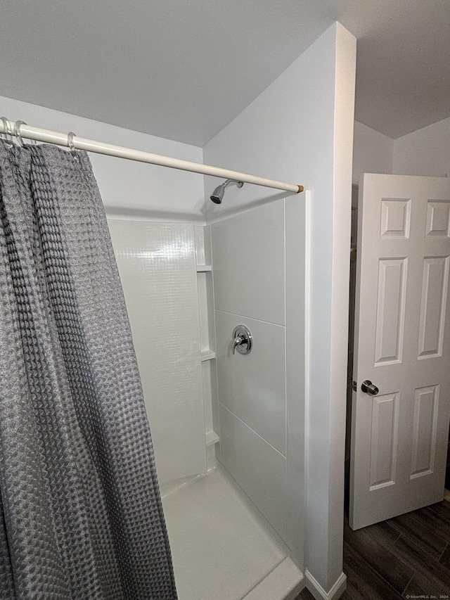 bathroom with curtained shower and hardwood / wood-style flooring