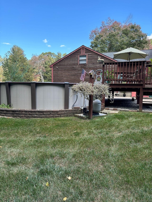 rear view of house featuring a lawn and a wooden deck