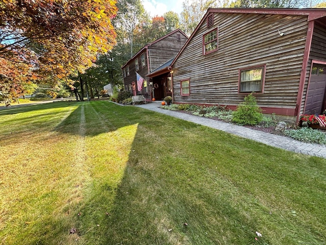 view of property exterior with a garage and a lawn