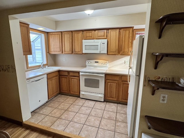 kitchen with light tile patterned flooring, white appliances, and sink