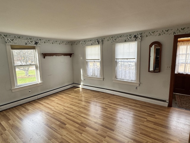 unfurnished room featuring light hardwood / wood-style floors and a baseboard radiator