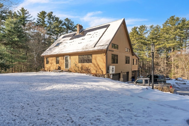 view of snow covered exterior with a garage