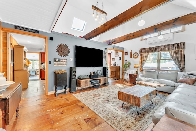 living room featuring a wall mounted air conditioner, light hardwood / wood-style floors, lofted ceiling with skylight, and sink