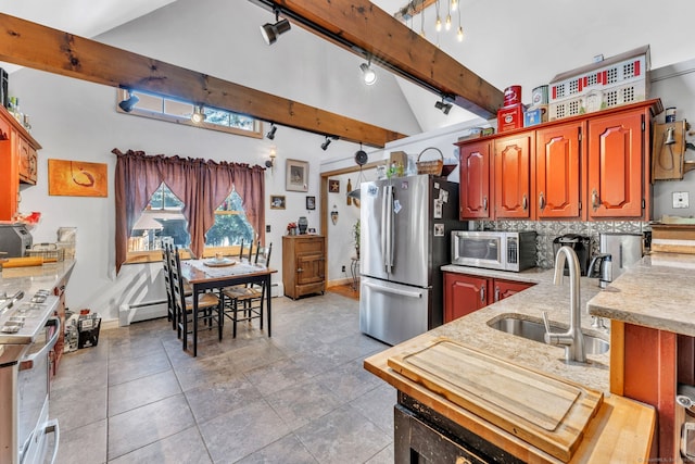 kitchen with a baseboard heating unit, track lighting, tasteful backsplash, beam ceiling, and stainless steel appliances