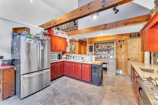 kitchen featuring beamed ceiling, sink, appliances with stainless steel finishes, and tasteful backsplash