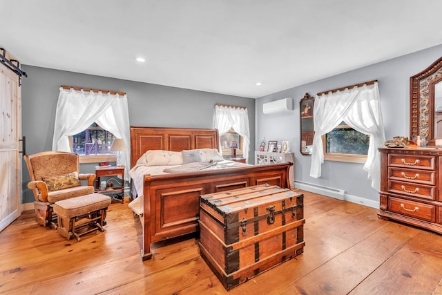 bedroom featuring multiple windows, light wood-type flooring, and a baseboard heating unit