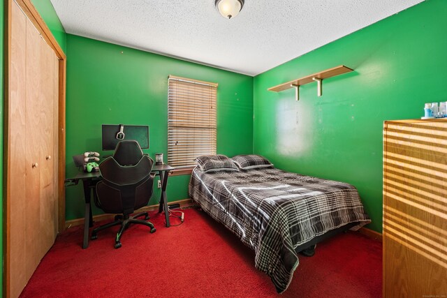 carpeted bedroom featuring a textured ceiling and a closet