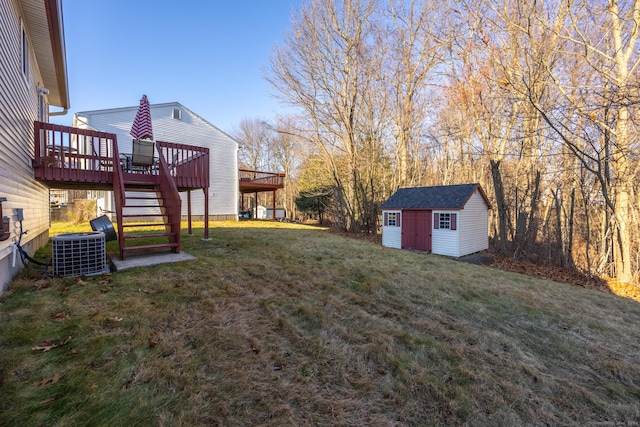 view of yard featuring central AC, a deck, and a storage shed