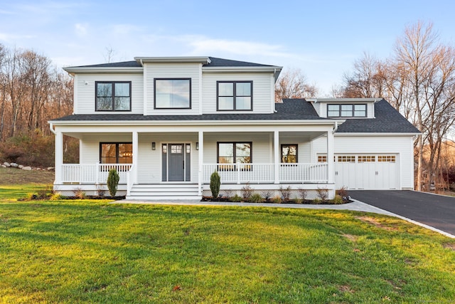 view of front facade with a porch, a shingled roof, an attached garage, driveway, and a front lawn