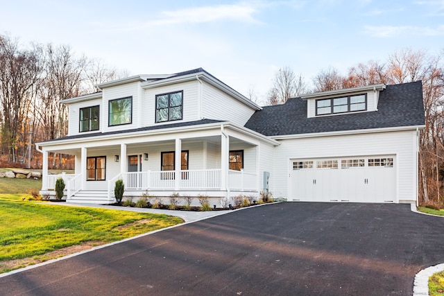 view of front of home featuring aphalt driveway, roof with shingles, an attached garage, a porch, and a front yard