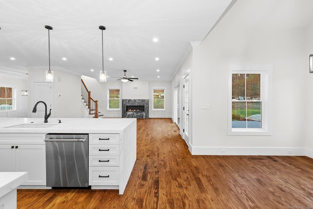 kitchen with stainless steel dishwasher, ceiling fan, sink, pendant lighting, and white cabinetry