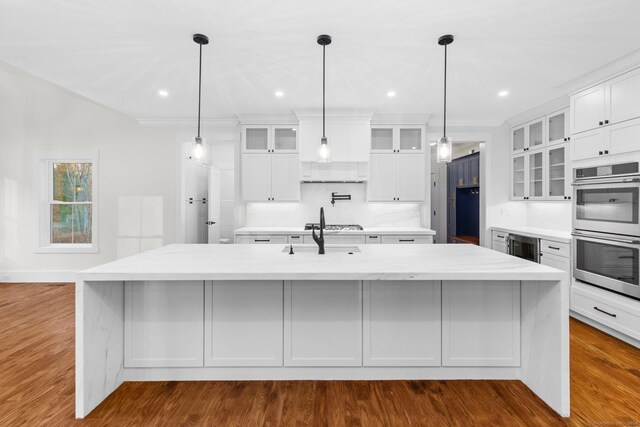 kitchen with white cabinetry, a large island, pendant lighting, and appliances with stainless steel finishes