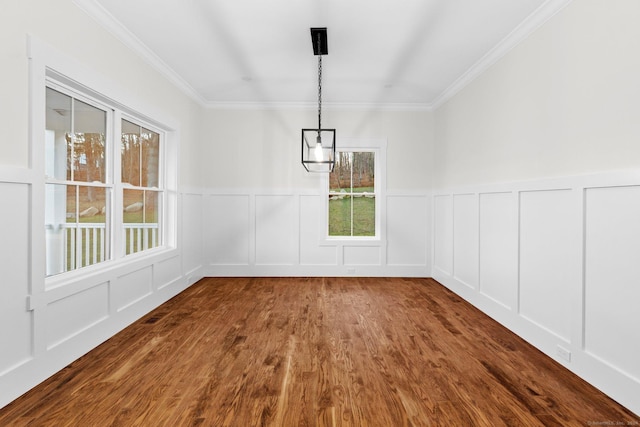 unfurnished dining area with wood-type flooring, plenty of natural light, and crown molding