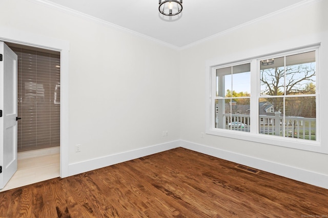 spare room featuring wood-type flooring and crown molding