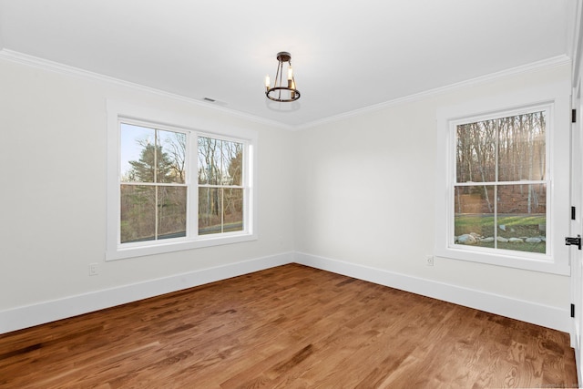 unfurnished dining area featuring hardwood / wood-style floors, crown molding, and an inviting chandelier