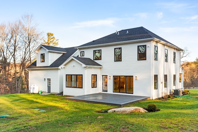 rear view of property featuring central AC, a yard, and a patio