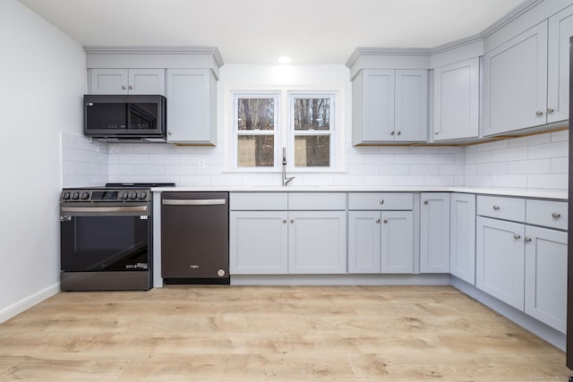 kitchen featuring decorative backsplash, range with electric cooktop, sink, dishwasher, and light hardwood / wood-style floors