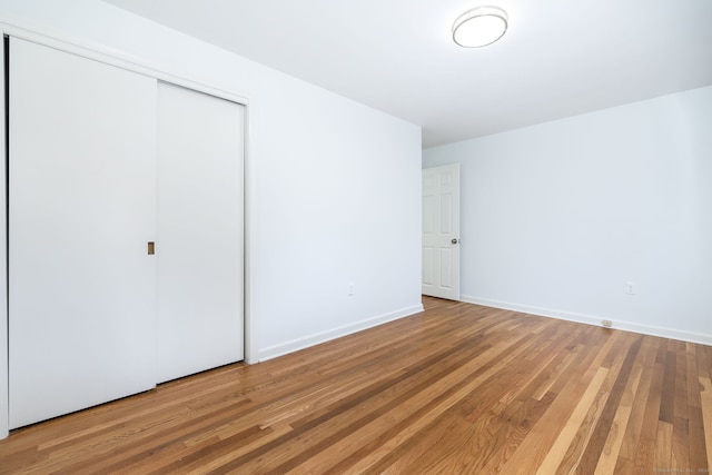 unfurnished bedroom with a closet and hardwood / wood-style flooring