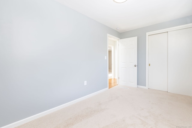 unfurnished bedroom featuring a closet and carpet floors