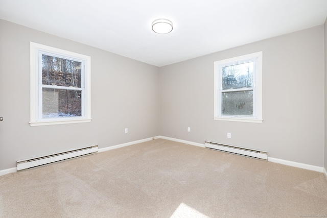 spare room featuring carpet flooring and a baseboard heating unit