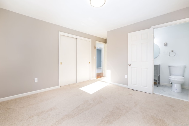 unfurnished bedroom with carpet flooring, ensuite bath, and a closet