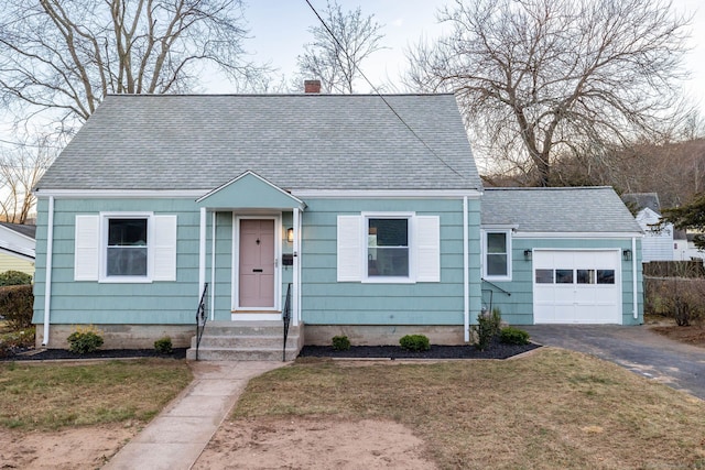 bungalow-style house featuring a garage and a front lawn