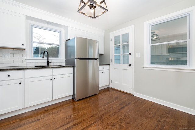 kitchen with white cabinets, dark hardwood / wood-style floors, sink, and stainless steel refrigerator