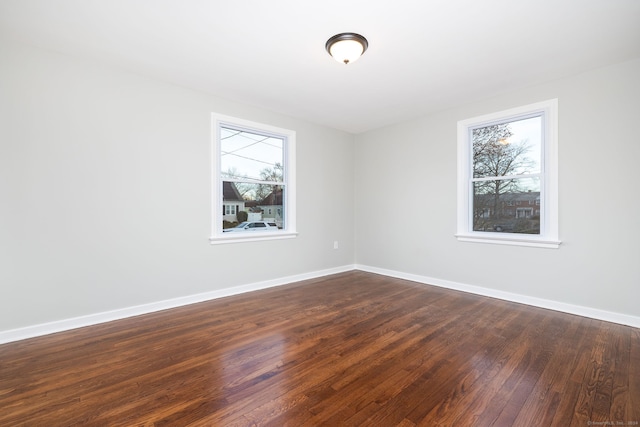 spare room with dark hardwood / wood-style floors and a wealth of natural light