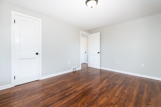 unfurnished room featuring dark wood-type flooring