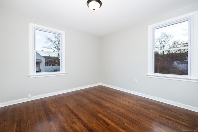 spare room with wood-type flooring and a wealth of natural light