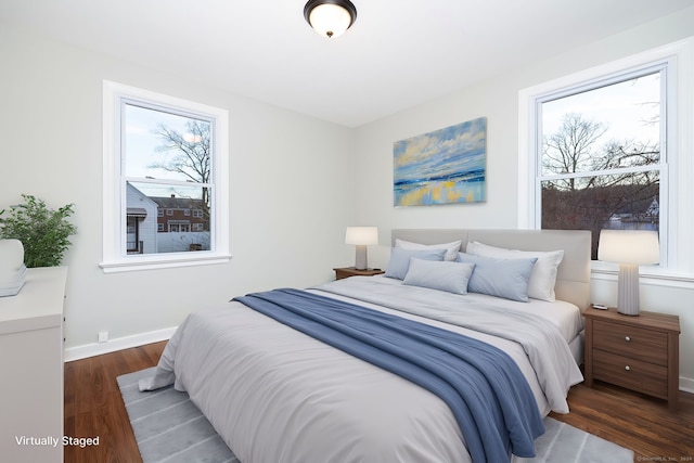 bedroom with dark wood-type flooring and multiple windows