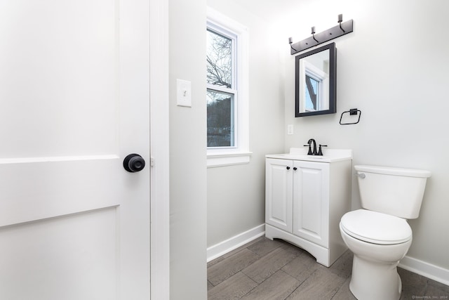 bathroom with hardwood / wood-style floors, vanity, and toilet