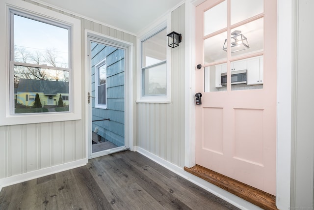 entryway featuring crown molding and dark wood-type flooring