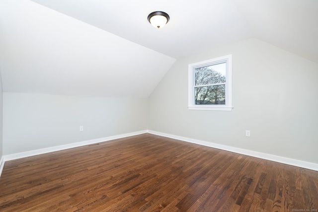 additional living space with dark hardwood / wood-style flooring and lofted ceiling