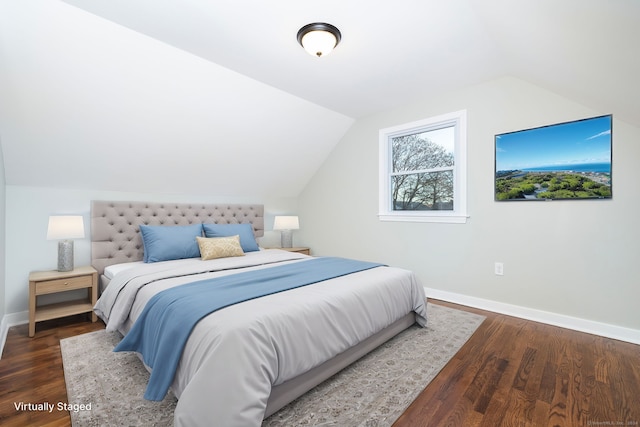 bedroom featuring dark wood-type flooring and vaulted ceiling