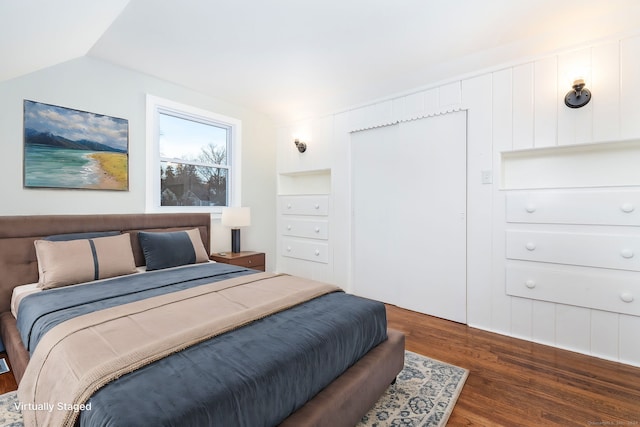 bedroom with dark hardwood / wood-style floors and lofted ceiling