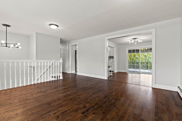 unfurnished room with a textured ceiling, dark hardwood / wood-style floors, and a notable chandelier