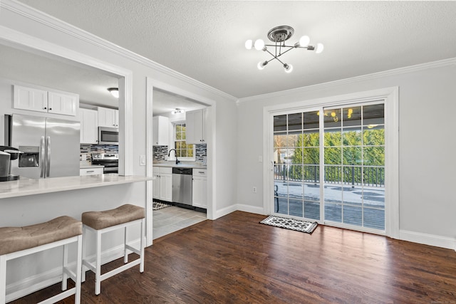 kitchen featuring a kitchen breakfast bar, decorative backsplash, dark hardwood / wood-style flooring, white cabinetry, and stainless steel appliances