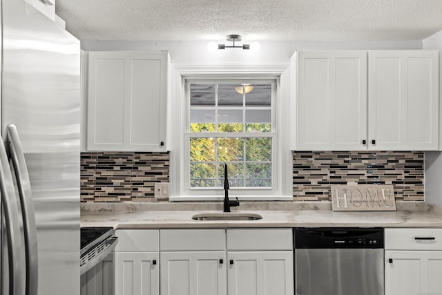 kitchen with white cabinetry, sink, appliances with stainless steel finishes, and tasteful backsplash