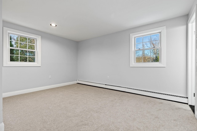 carpeted empty room with a wealth of natural light and a baseboard radiator