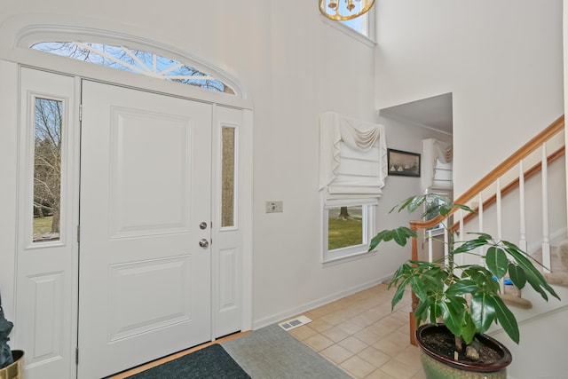 entryway featuring light tile patterned floors and a high ceiling