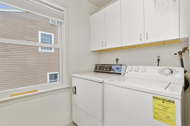 clothes washing area featuring cabinets, separate washer and dryer, and a wealth of natural light