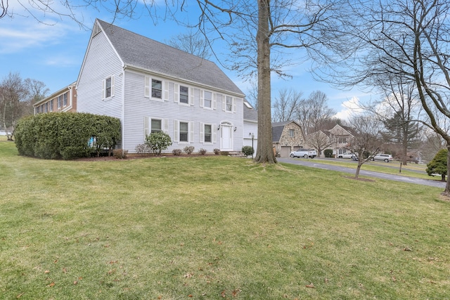 colonial inspired home featuring a front lawn